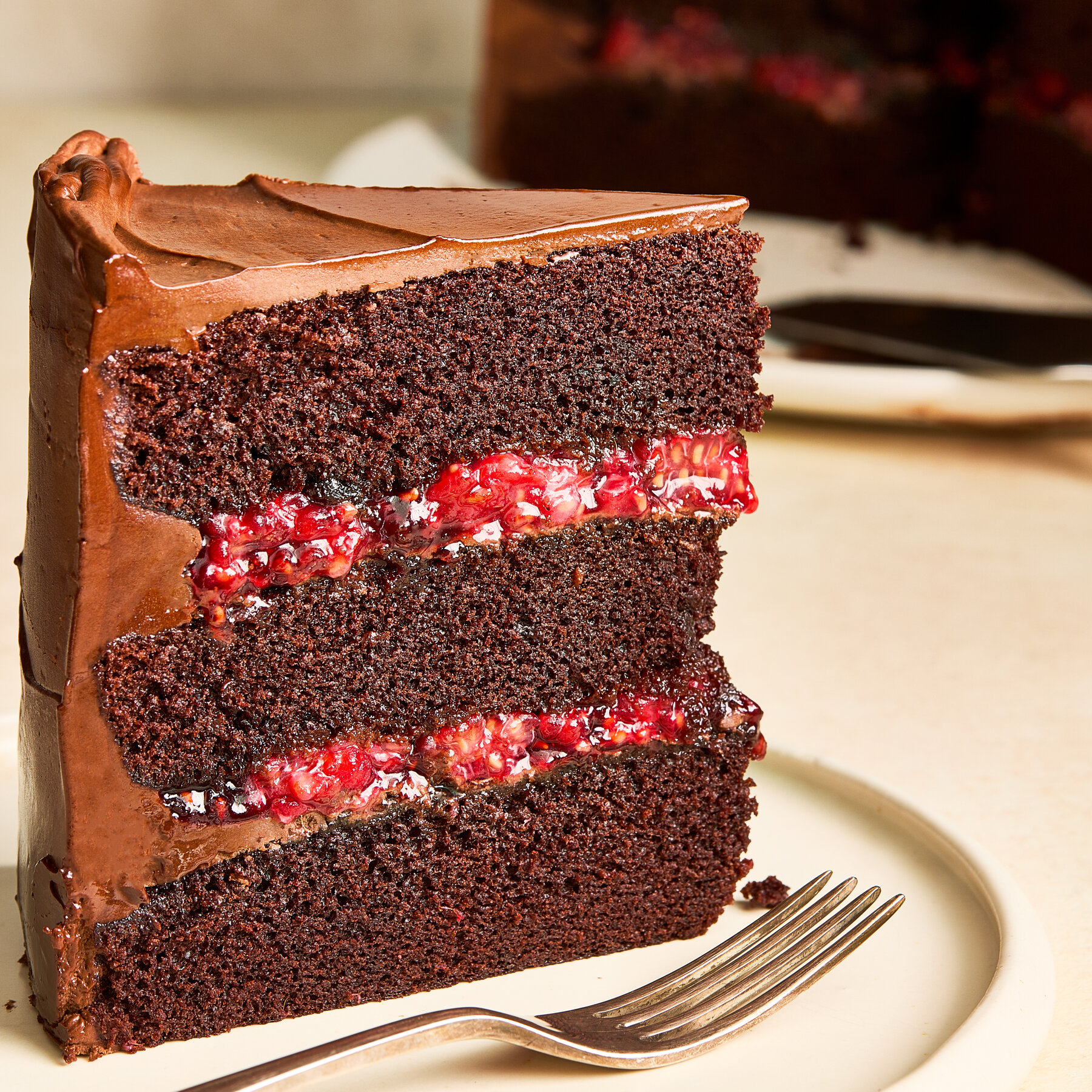 Finished chocolate raspberry layer cake with raspberries on top